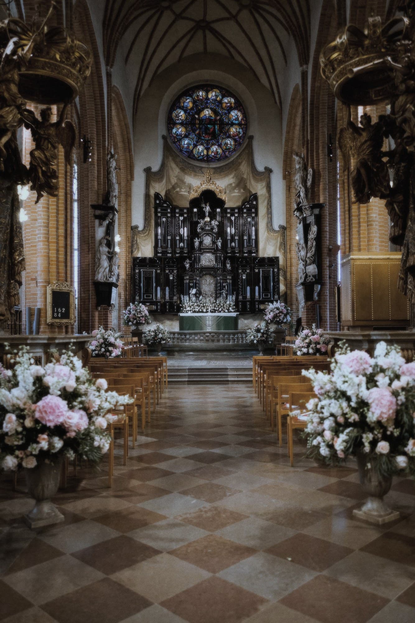 Storkyrkans kor klätt till bröllop, med arrangemang i rosa och vitt längs bänkraderna