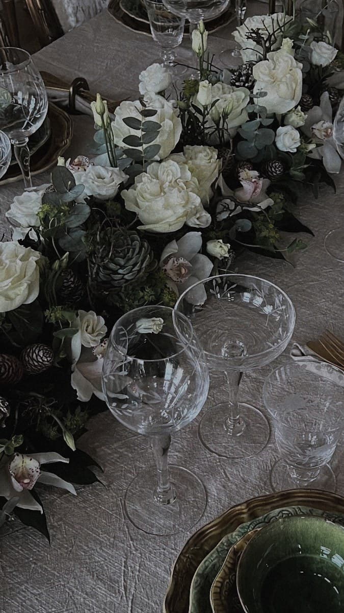 Vinterdukning med kristall, gröna glas och arrangemang i vitt och grönt
